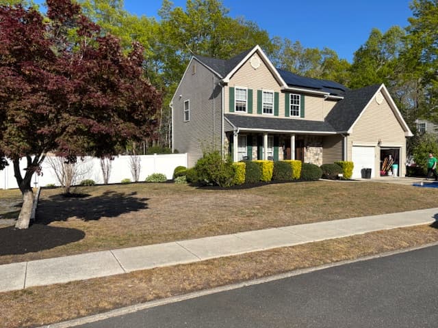 Refreshed front yard with mature red maple and trimmed beds on a Linwood, NJ colonial
