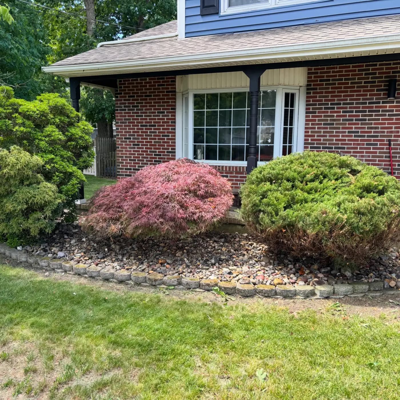 River-rock garden bed border around a brick home in South Jersey