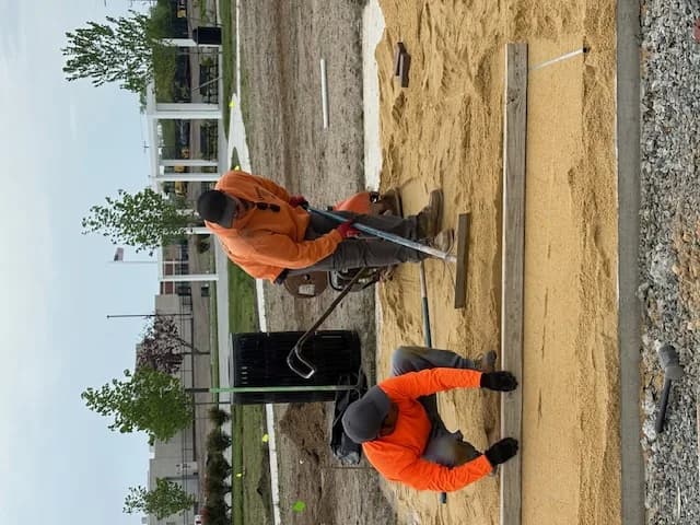 Crew screeding a compacted sand base for a paver patio in Galloway, NJ